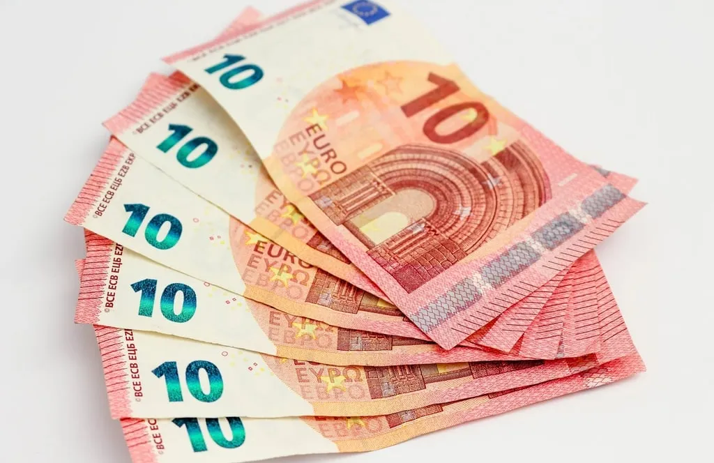 A fan of ten euro banknotes on a white surface