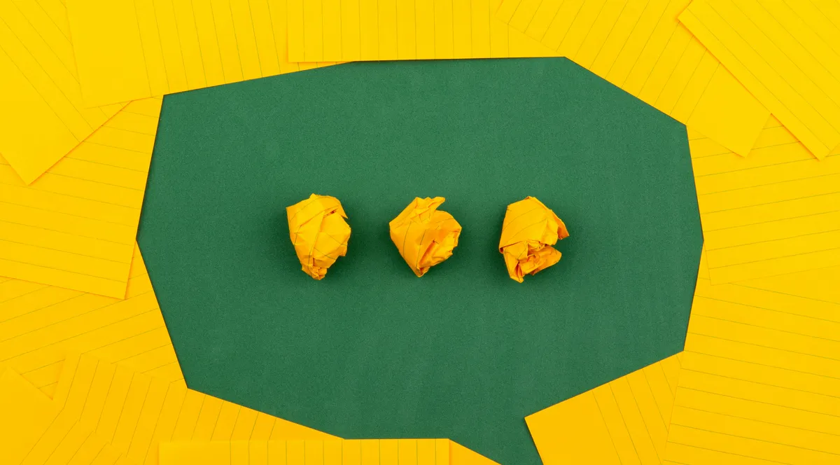 A green paper speech bubble holding three crumpled yellow notes