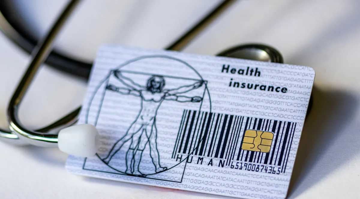 A health insurance card resting against a stethoscope