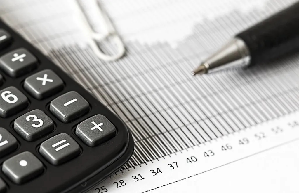 A calculator and a pen resting on a printed chart