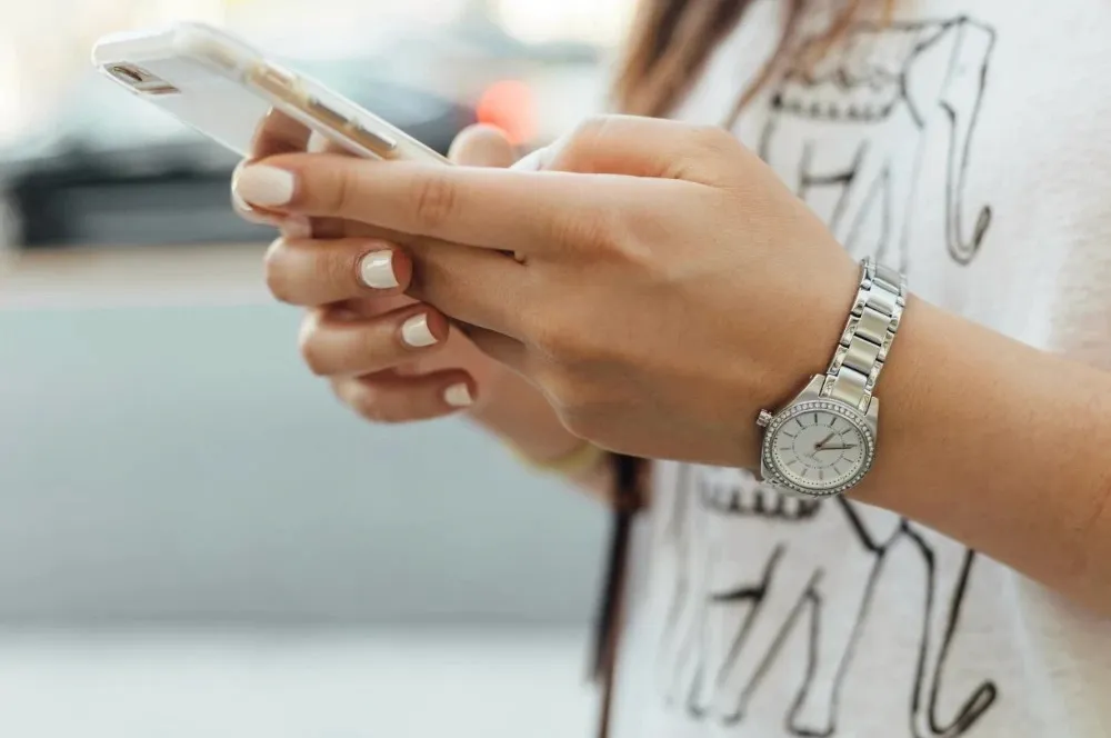 A woman holding a smartphone in both hands