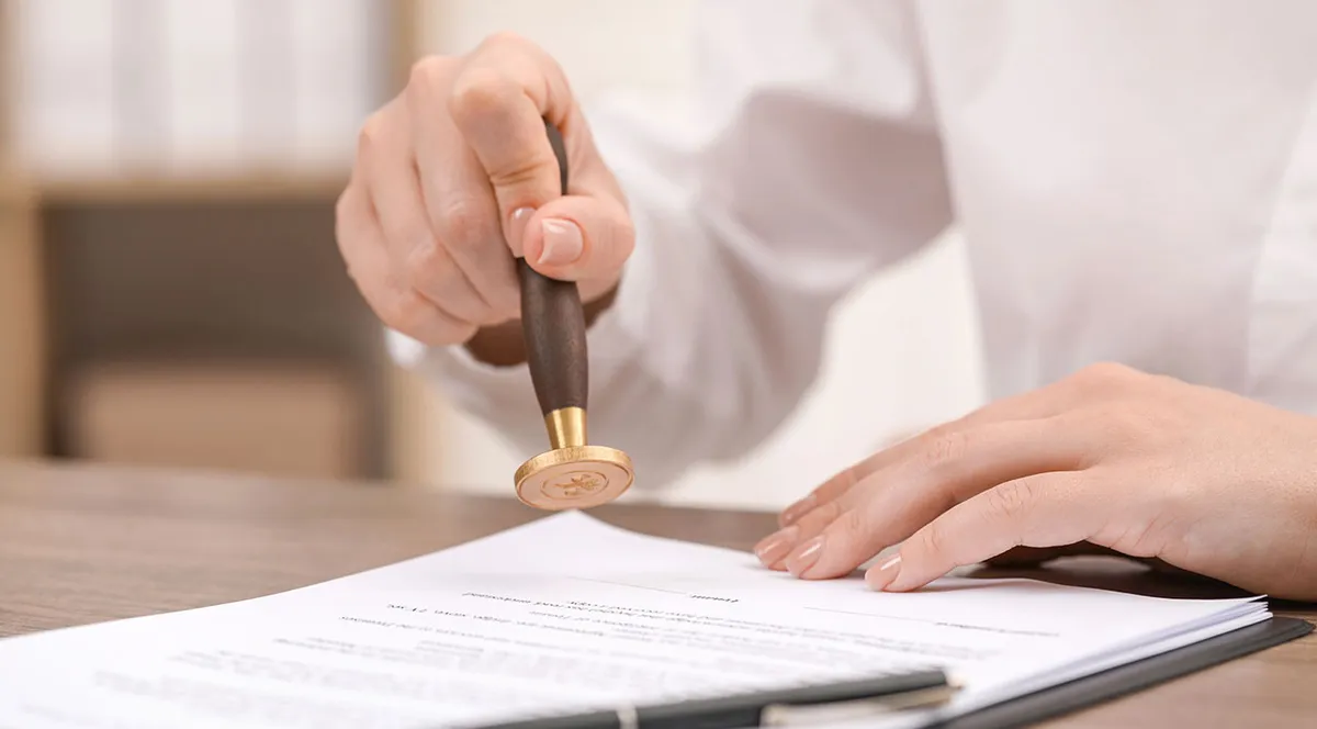 A hand stamping an official document