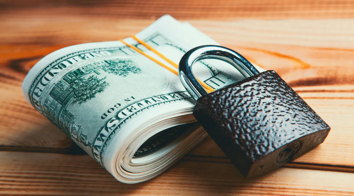 A 20 dollar bill next to a small padlock
